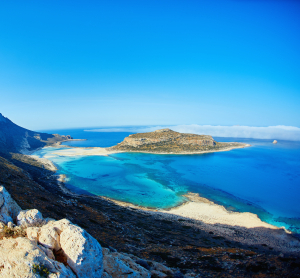 Atemberaubender Blick auf die Lagune von Balos auf Kreta mit t&uuml;rkisblauem Wasser, Sandstr&auml;nden und felsiger K&uuml;stenlandschaft unter klarem Himmel.