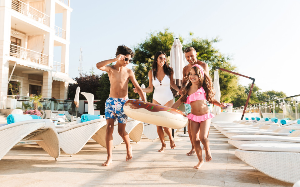 Familie mit Kinder am Pool eines Familienhotels