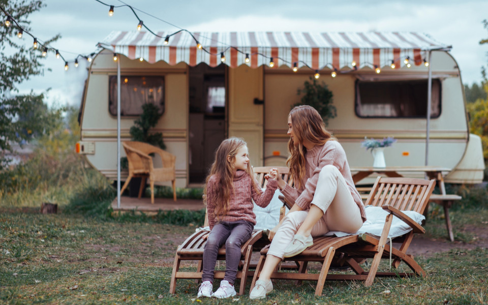 Mutter mit Tochter vor einem Wohnwagen