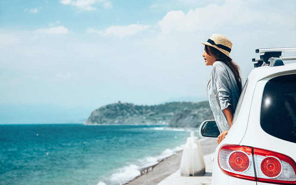 Frau im Auto nähe der Küste mit Meer